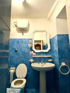 a blue tiled bathroom with a toilet and a sink at Appartamento con terrazza vista mare nel borgo in Framura