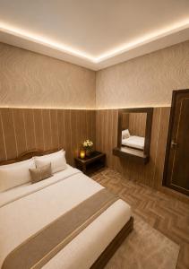 a bedroom with a large bed and a mirror at Hotel New Lucknow in Lucknow