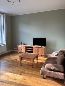 a living room with a couch and a flat screen tv at Gästehaus LeLo 6 in Solingen