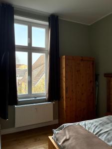 a bedroom with a bed and a large window at Gästehaus LeLo 6 in Solingen