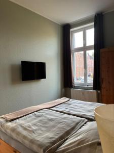 a bedroom with a bed with a television on the wall at Gästehaus LeLo 6 in Solingen +27 photos