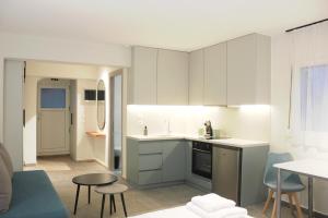 a kitchen with white cabinets and a table and chairs at Thassos Studio Kai Lani in Potamiá