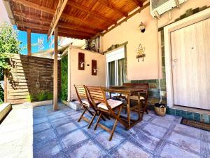 a patio with a wooden table and chairs at Olea Central Stay in Nea Kallikrateia +16 photos