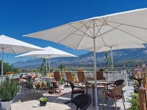 a patio with tables and chairs and umbrellas at Guest House Juald in Gjirokastër +34 photos