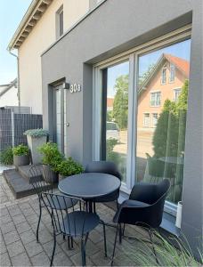 a patio with a table and chairs in front of a window at Luxury Apartment Vorstetten Modern Zentral in Vörstetten