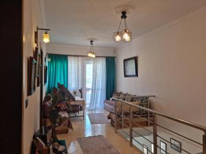 a living room with a staircase and green curtains at Guest House Juald in Gjirokastër