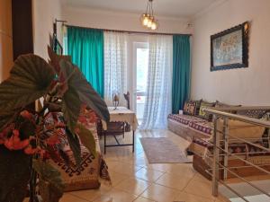 a living room with green curtains and a couch at Guest House Juald in Gjirokastër