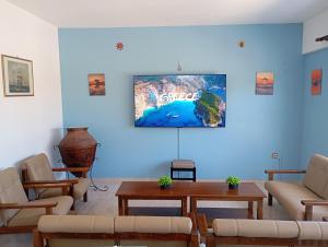 a living room with couches and a map on the wall at Dina Apartments Kokkari, Pension Dina, Dina Rooms in Kokkari