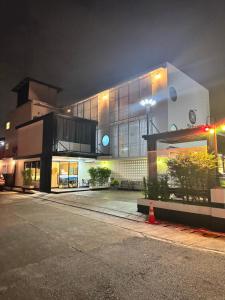 a large building at night with a street at PG Ryoichi Hotel in Chiang Rai