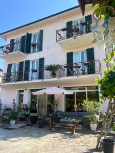 a hotel with a patio and an umbrella at Hotel Momora in Bardineto