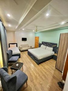 a bedroom with two beds and a living room with a couch at Emerald Inn in Islamabad
