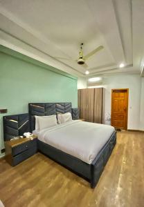 a bedroom with a large bed in a room at Emerald Inn in Islamabad +2 photos