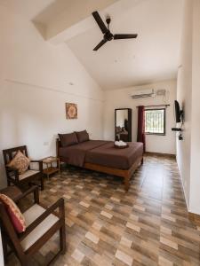 a bedroom with a bed and a ceiling fan at Vinsons Cottages in Colva