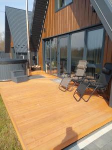 two chairs on a wooden deck next to a building at zatyshnyy dvoryk Затишний Дворик in Kolomiya +4 photos
