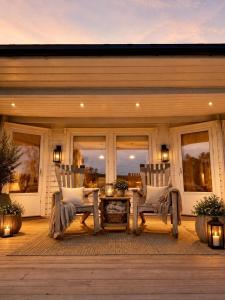 a patio with two chairs and a table on a house at Willes Wellness Paradise in Herjenes