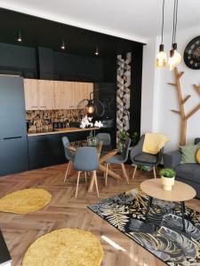 a living room with a couch and a table and chairs at Apartament Kamil Kalisz in Kalisz