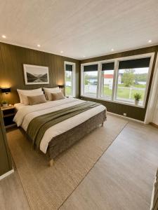 a large bedroom with a large bed and windows at Willes Wellness Paradise in Herjenes