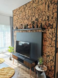 a living room with a tv and a stone wall at Apartament Kamil Kalisz in Kalisz