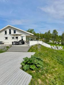 a house with a porch and a deck with a garden at Willes Wellness Paradise in Herjenes