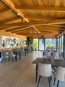 a dining room with wooden ceilings and tables and chairs at Joni`s Guesthouse in Shkodër
