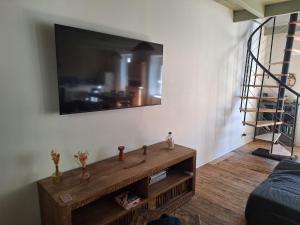 a living room with a television on a wall at La maison COP&CO in Murat-sur-Vèbre +7 photos