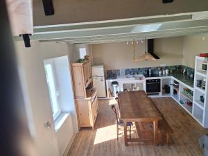 a kitchen with a wooden table and chairs in it at La maison COP&CO in Murat-sur-Vèbre