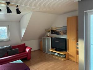 a living room with a red couch and a tv at FeWo Saier in Althengstett
