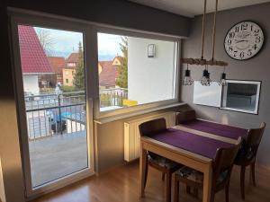 a dining room with a table and a balcony with a clock at FeWo Saier in Althengstett +29 photos
