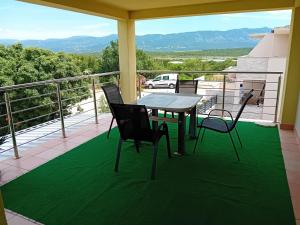 a patio with a table and chairs on a balcony at D,apartman' ulica pušća 51, 51513 Omišalj in Omišalj