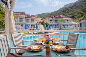 a table with breakfast food on the balcony of a resort at Mozaik Apartments in Oludeniz