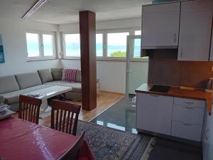 a kitchen and living room with a couch and a table at D,apartman' ulica pušća 51, 51513 Omišalj in Omišalj
