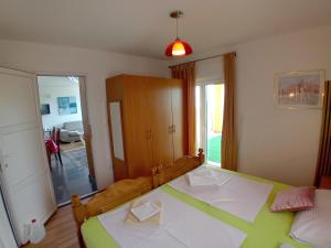 a bedroom with a green and white bed in it at D,apartman' ulica pušća 51, 51513 Omišalj in Omišalj