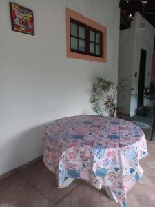 a quilt on a table in a room at Chalé casa na mata Jasmim in Guararema