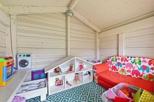 a play room with a red couch and toys at Vagunmaja in Haapsalu
