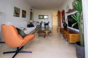 a living room with a couch and a chair at appartement gelegen aan de golfbaan op La Quinta Benahavis Marbella in Benahavís