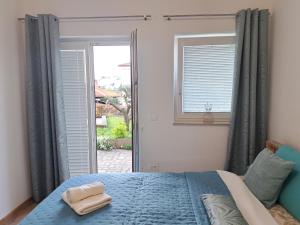 a bedroom with a blue bed and a window at Dorea in Jagodje