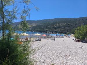 a beach with umbrellas and people sitting on it at Luna di mare Igalo in Igalo