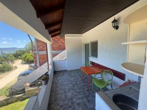 a balcony of a house with a table and a view at Apartmani Konak in Star Dojran