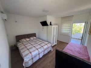a bedroom with a bed and a tv in it at Apartmani Konak in Star Dojran