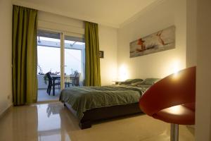 a bedroom with a bed and a table with a chair at appartement gelegen aan de golfbaan op La Quinta Benahavis Marbella in Benahavís +33 photos