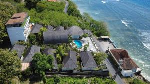 an aerial view of a house on a hill next to the water at SUITE OCEAN BLUE in Nusa Penida