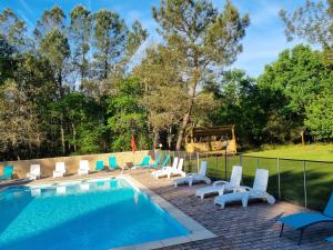 a pool with chaise lounge chairs and a swimming pool at Les Palafitos in Luglon