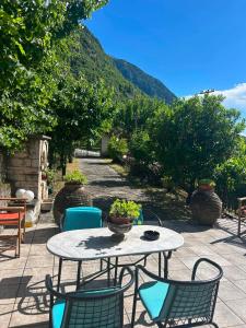 a patio with a table and chairs and a mountain at Epavlis Elena in Konitsa