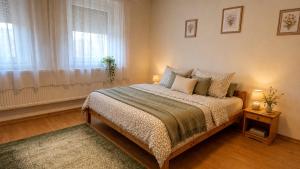 a bedroom with a bed and a window at Zöld Vendégház in Csernely