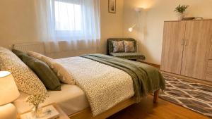 a bedroom with a bed and a chair at Zöld Vendégház in Csernely +13 photos