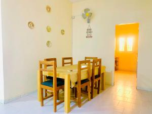 a dining room with a wooden table and chairs at Catalan du walo in Richard Toll