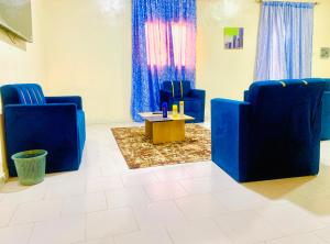 a waiting room with blue chairs and a coffee table at Catalan du walo in Richard Toll