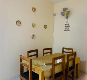 a dining room table with chairs and a fan on the wall at Catalan du walo in Richard Toll +11 photos