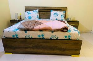 a bedroom with a bed with a wooden headboard at Catalan du walo in Richard Toll