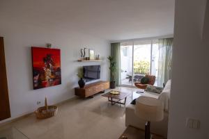 a living room with a couch and a tv at appartement gelegen aan de golfbaan op La Quinta Benahavis Marbella in Benahavís